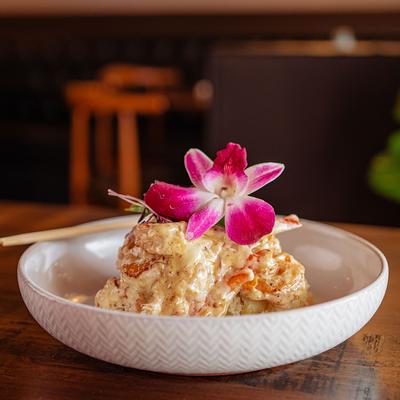 Peruvian shrimp served on plate with purple flower garnish