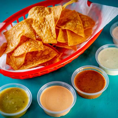Tortilla chips with different dipping sauces.