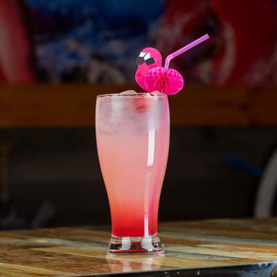 A pink cocktail in a tall glass with a flamingo straw.