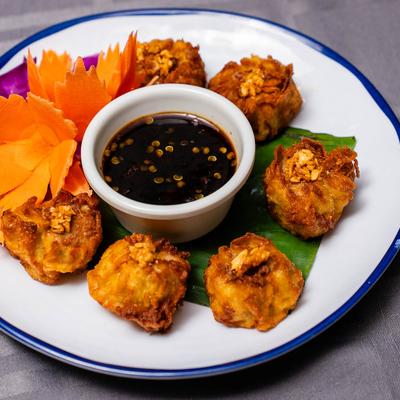 Fried Dumplings served with a cup of sweet and sour black sauce.