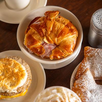 Biscuit sandwich croissant sandwich, beignets,  and coffee.