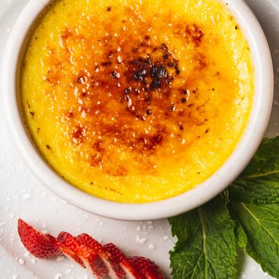 Crème Brûlée, with strawberry slices on the side