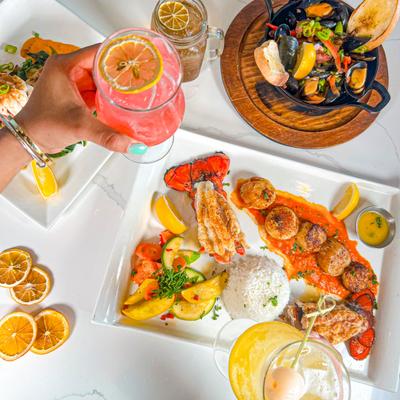 Colorful seafood dishes and cocktails on a table.