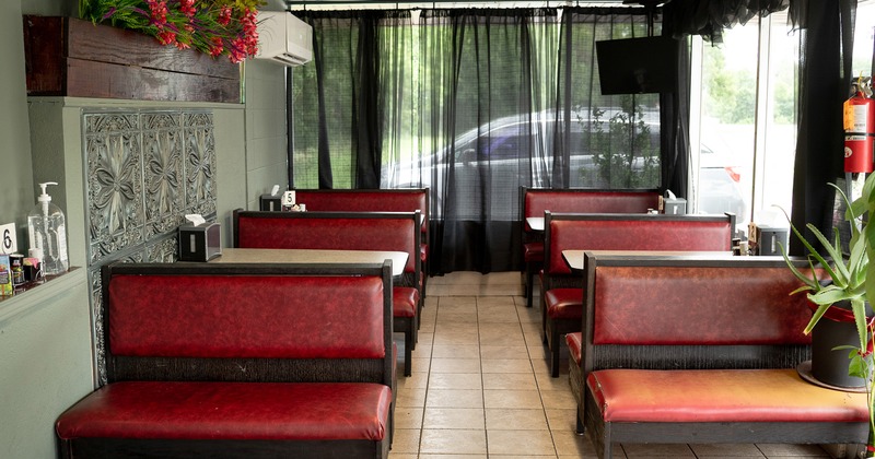 Cozy interior dining area with upholstered red booths