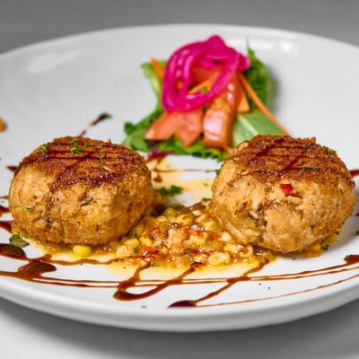 Crab cakes served with corn and mango chutney and a fresh salad.