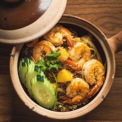 Thai-style pineapple fried rice served in a clay pot.