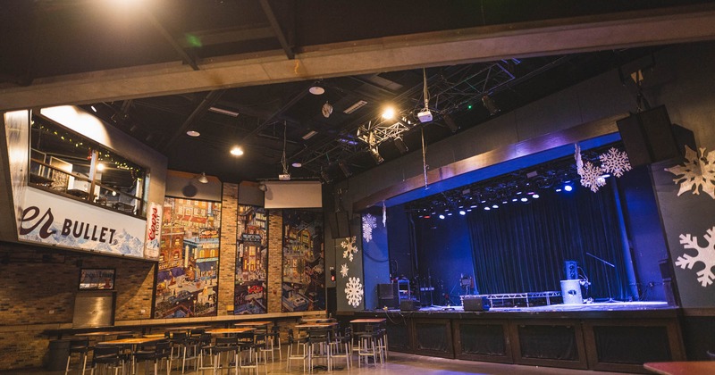 Interior, concert hall, equipped stage, yellow brick walls with murals, stage lighting