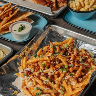 Loaded fries topped with bacon, cheese, and scallions.