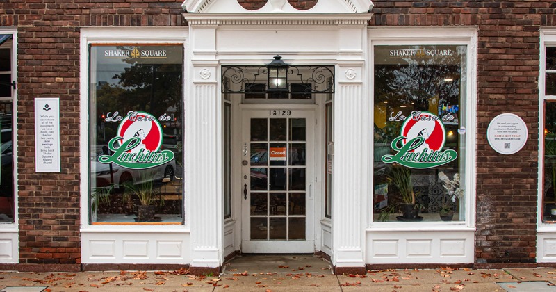Restaurant storefront with a white entrance and large windows displaying Luchita’s logo