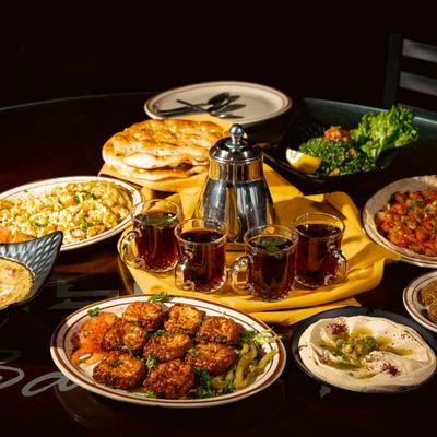 Assorted food plates and glasses filled with tea.