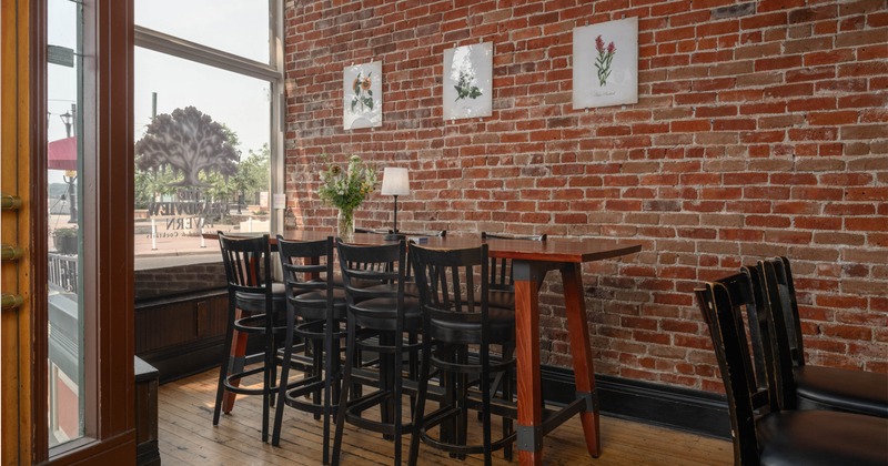 Interior, high seating table for eight, shop window, red brick walls