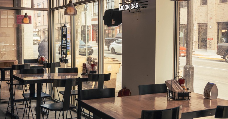 High-top table seating large windows and neon signage