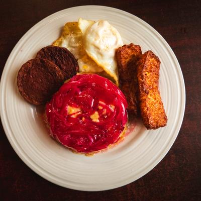 MAshed plantains with pickled red onions, fried cheese, fried salami, and eggs.