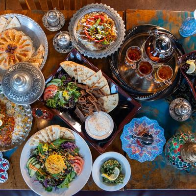 Various Middle Eastern dishes and tea served on a table.