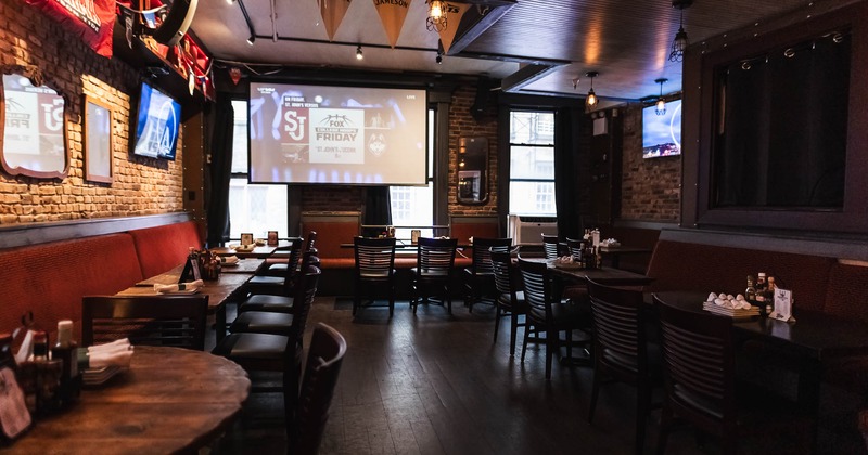 Interior, tables all lined up with tableware on the table with big TV in the back