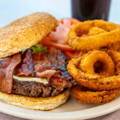 Bacon Burger with onion rings on the side.