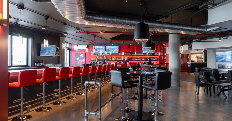 Interior, round tables with stools with the bar in the back