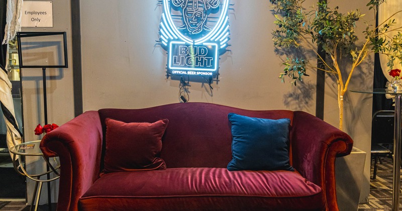 Interior, seating place with sofa in front of neon sign on the wall