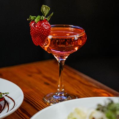 A Strawberry Daiquiri cocktail served in a coupe glass, garnished with a fresh strawberry