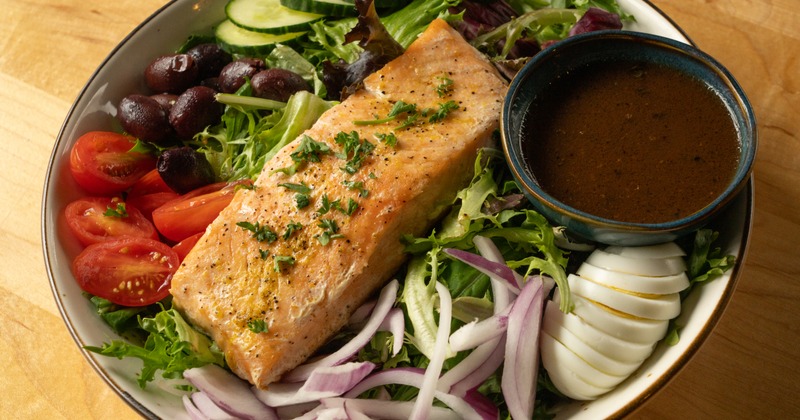 Salmon fillet on mixed greens with dressing cup