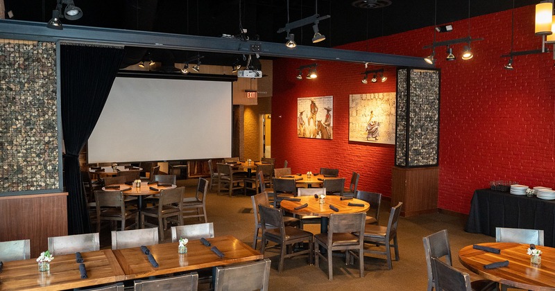 Restaurant interior, event space with dining tables and projection screen