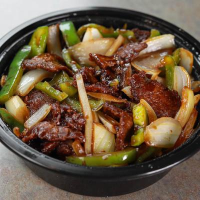 Steak, with green bell peppers and onions in a brown sauce.