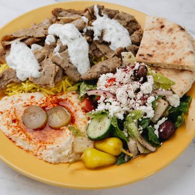 Gyro meat topped with tzatziki sauce, served with rice, hummus, pita and a salad.