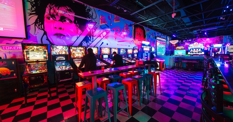 Interior, table with bar stools near the bar, game machines