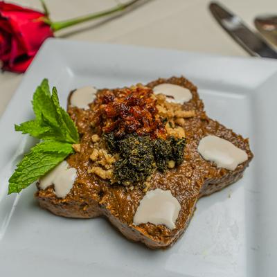 Baked eggplant topped with whey sauce, sauteed onions, and mint.