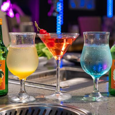 Various cocktails served on the table alongside a bottle of beer.