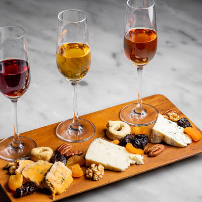 Glasses of Wine and cheese on a board