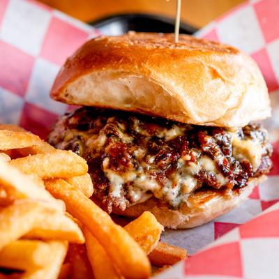 Cheeseburger with melted cheese and caramelized onions served with fries.