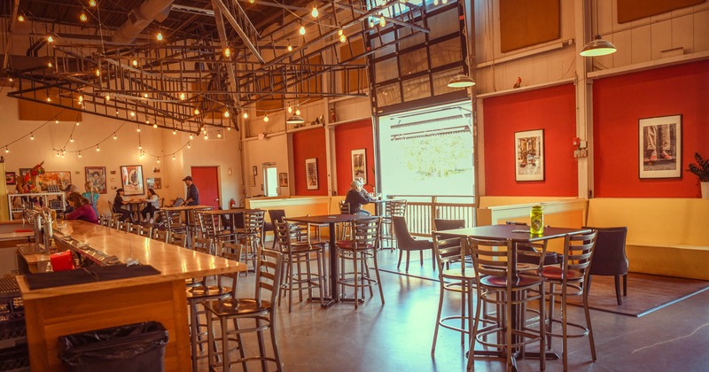 Interior, tables and chairs ready for guests, bar on the left
