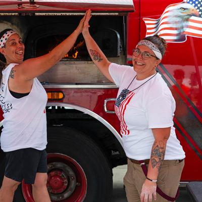 Two food truck workers high fiving each other.