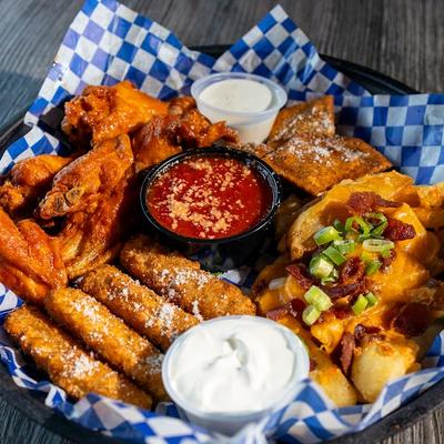 Combo plate with hot wings, mozzarella sticks, loaded fries, toasted ravioli, and condiments.