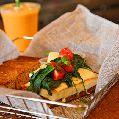 Fresh bread with cheese and mixed salad, orange juice in the back