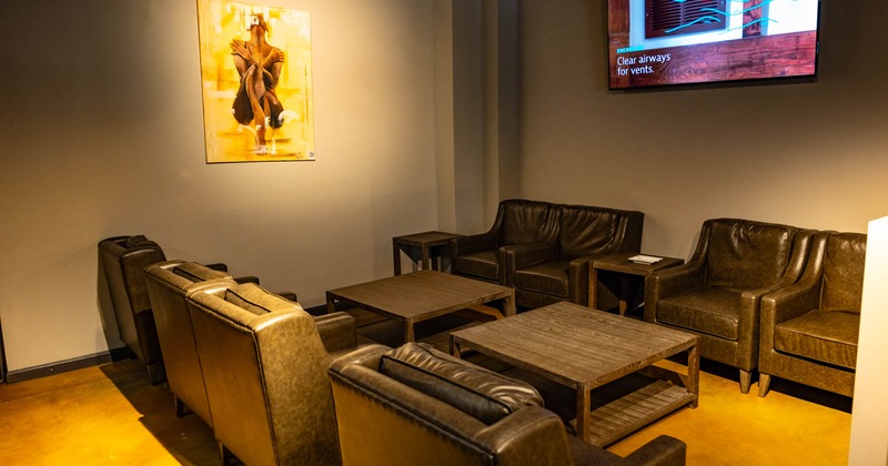 Interior, leather armchairs and coffee tables, TV screen on the wall