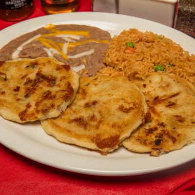 Stuffed corn masa cakes served with Mexican rice and refried beans, topped with melted cheese.