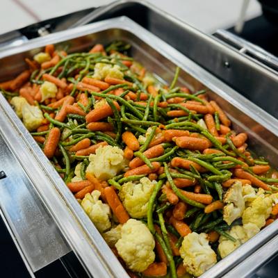 Cooked cauliflower, carrots, and green beans in a large serving container.