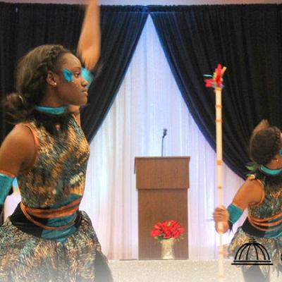 Performer holding a tall ceremonial staff.