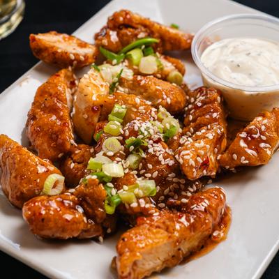 Thai chicken bites topped with sweet chili sauce, scallions and sesame seeds.