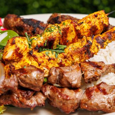 Mixed kebab platter featuring grilled chicken and beef, close up.