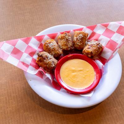 Tater kegs served with beer cheese dip on a plate.