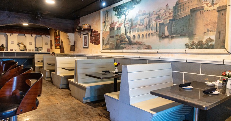Cozy interior dining area with dining booths set for two guests along the wall