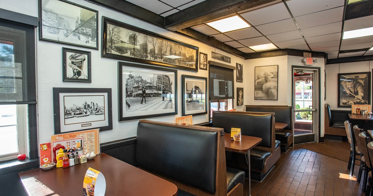 Booth tables and a wall filled with framed black and white photographs
