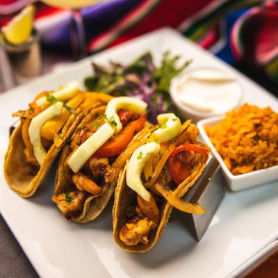 Three tacos, salad and vegetables