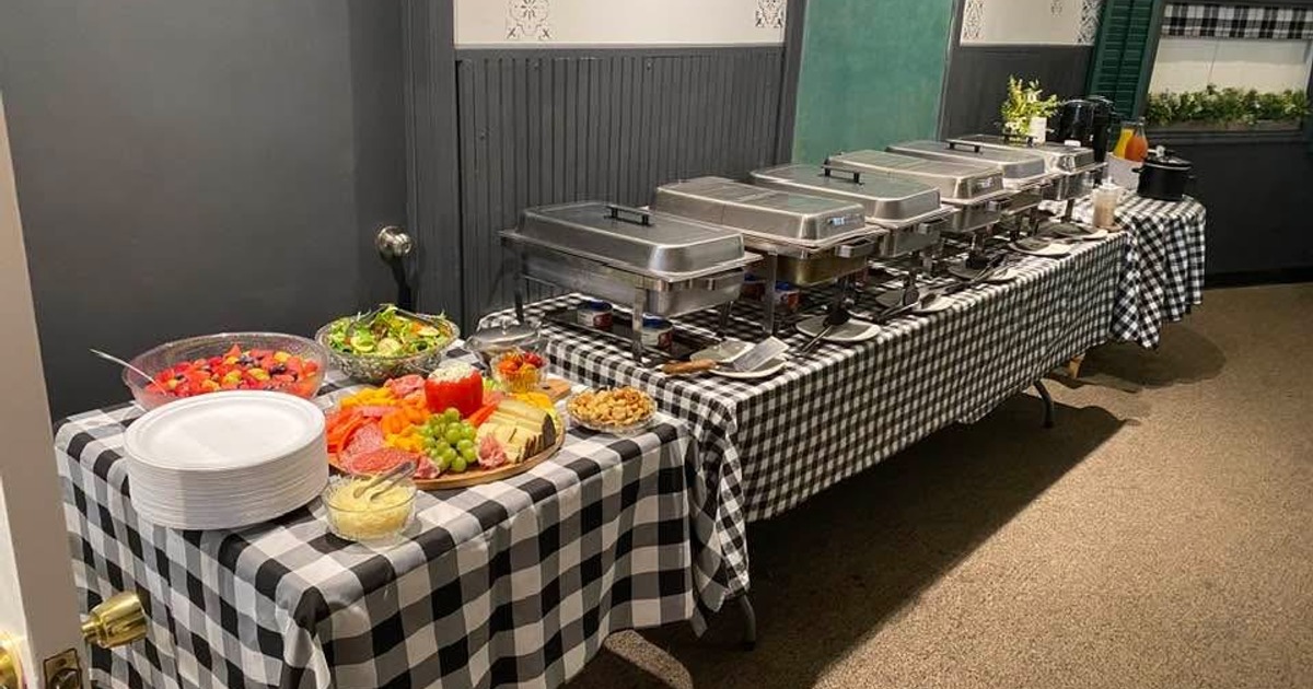 Catering buffet setup with a variety of dishes served in stainless steel chafing dishes