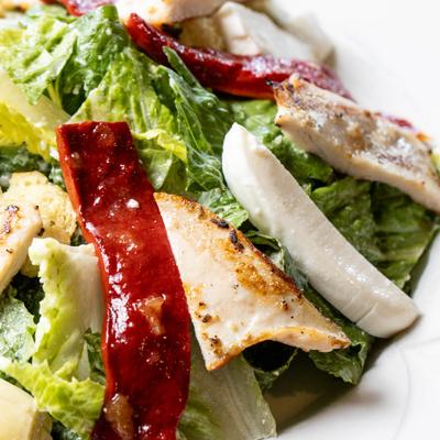 Salad with lettuce, tomatoes, artichoke hearts, roasted red peppers, and mozzarella.