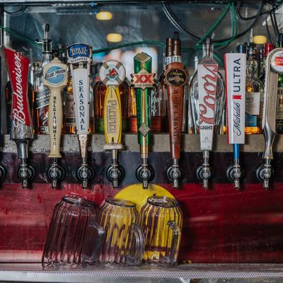 Beer taps with labeled handles, clean glasses below.