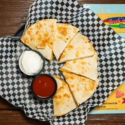 Quesadilla served with salsa and sour cream, top view.